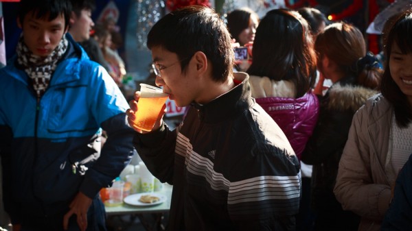 Một khách tham quan đang thưởng thức bia Séc tại gian hàng của các sinh viên CH Séc.
